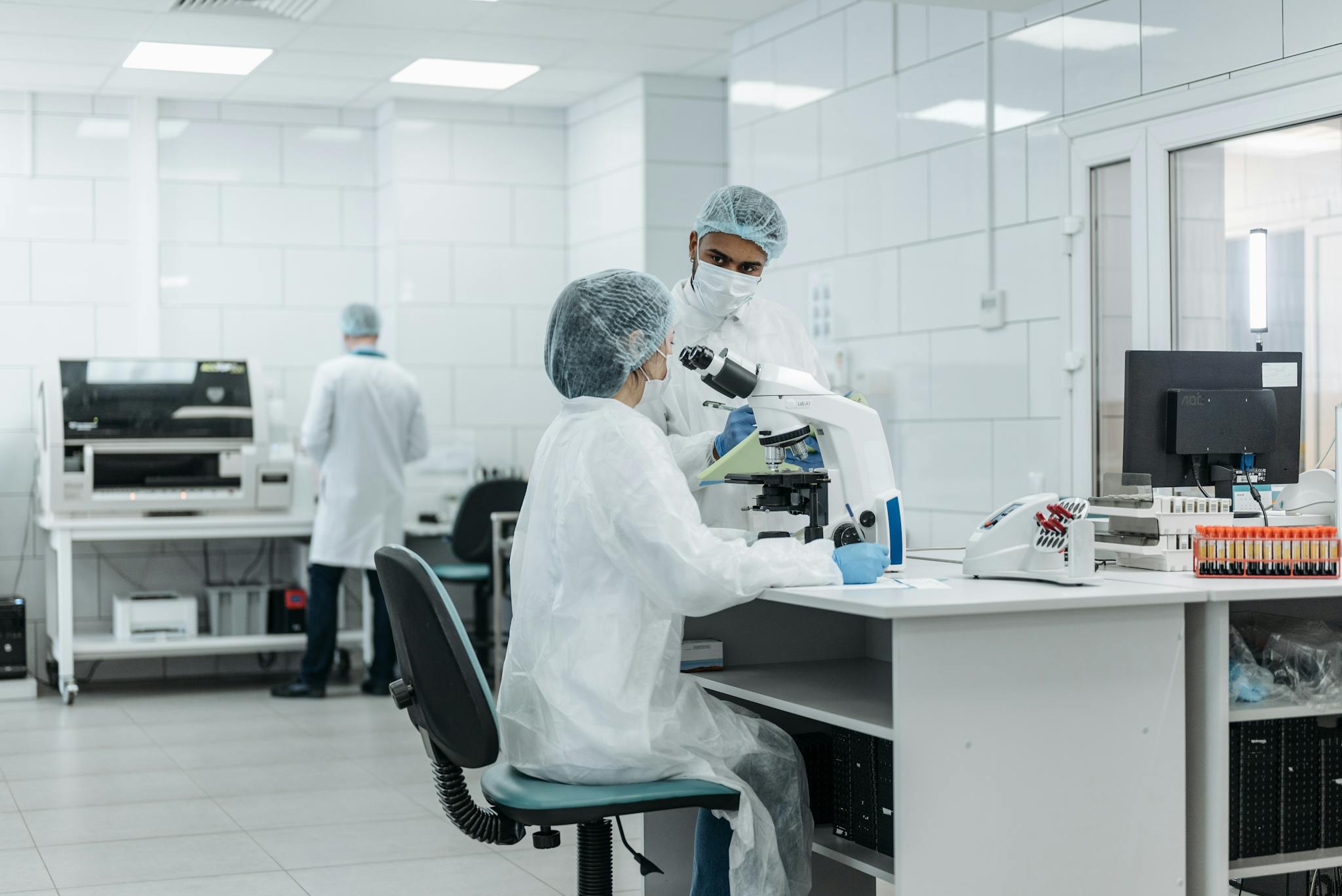 Laboratory scientists conduct research using advanced microscopes in a well-equipped lab.