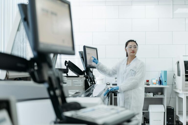 Lab technician in a white coat using medical equipment in a modern laboratory setting.